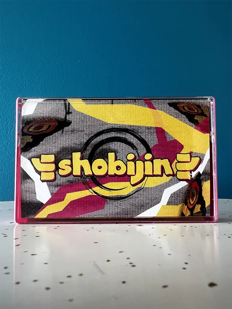 Shobojin cassette tape cover, depicting Mothra wings and colorful slashes.