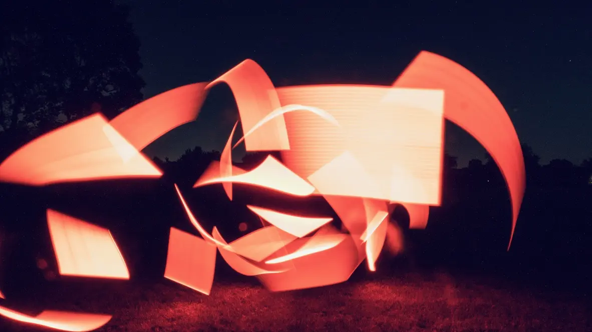 Experimental photograph with psychedelic, colorful shapes in a field outdoors at night.